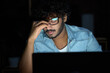 © insta_photos - Tired sleepy stressed overworked young indian business man student wearing glasses feeling lack of sleep, having eyestrain vision problem, using laptop computer working late at night at home office.