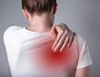 © valiantsin - Woman suffering from shoulder blade pain. Trigger point. Hand holding shoulder with red spot closeup. Back injury. Health care, medicine concept. High quality photo
