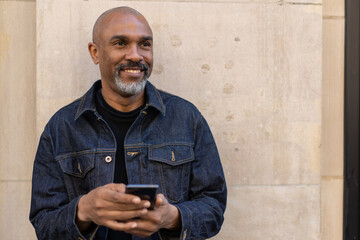 Poster - Mature black man in city using cell phone