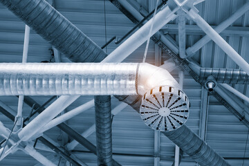 Poster - Ventilation pipes in silver insulation material hanging from the ceiling inside new building.