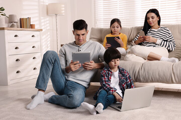 Poster - Internet addiction. Family with different gadgets in living room