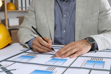 Wall Mural - Architect working with construction drawings in office, closeup