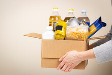 Woman Hands Holding Cardbox With Grocery Products. Volunteer Collecting Food Into Donation Box. Donation, Charity, Food Bank, Help For Poor Families, Migrants, Refugees