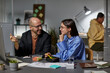 © Seventyfour - Portrait of smiling adult man talking to female colleague while working together late in office
