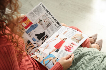 Canvas Print - African-American woman reading fashion magazine at home, closeup