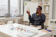 © Seventyfour - Portrait of black teacher using wheelchair and holding molecule models during chemistry class in school