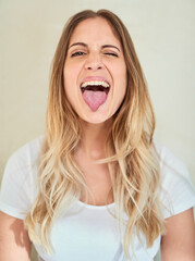 Wall Mural - Lets be silly together. Portrait of an attractive young woman sticking out her tongue.