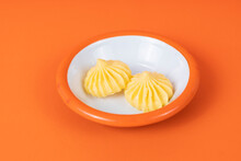 Close-up Shot Of White Plate With Butter And Orange Rim In Isolated Area, Orange Background With Selective Focus From Opposite Or Side Angle.