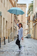 © Jose - Woman walking down the street on a rainy day with umbrella