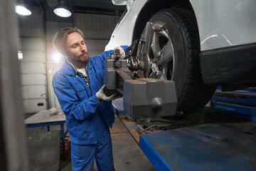 Wall Mural - Worker performing car maintenance at service station