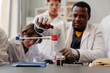 © Seventyfour - Close up of African American teacher demonstrating science experiments in school chemistry lab, copy space