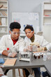 © Seventyfour - Vertican portrait of two curious African American children watching science experiments in chemistry lab at school