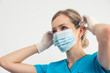 © PoppyPix - Responsible Nurse Putting On Medical Face Mask. Protection from bacteria and viruses. High quality photo