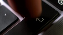 Person Finger Presses Repeatedly Enter Key On Contemporary Laptop Keyboard Extreme Closeup. Nervous User And Computer Problem. Technology Issues