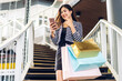 Portrait of smiling beauty asian fashion happy woman relax and enjoy shopping time summer sale walk and holding shopping colorful bag to buy something purchases use smartphone at store
