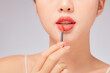 © Tuan  Nguyen  - Front view of model using lipstick in white background for cosmetic advertising