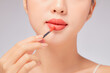 © Tuan  Nguyen  - Front view of model using lipstick in white background for cosmetic advertising