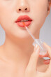 © Tuan  Nguyen  - Front view of model using lipstick in white background for cosmetic advertising