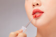 © Tuan  Nguyen  - Front view of model using lipstick in white background for cosmetic advertising