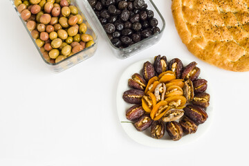 Walnut,apricot, date fruit plate with Ramadan Bread and olives on white surface.Top view