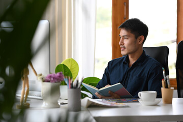 Wall Mural - Handsome male employee working with computer at bright modern workplace.