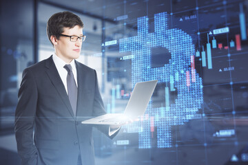 Poster - Attractive young caucasian businessman holding laptop with creative glowing bitcoin grid forex chart hologram on blurry office interior background. Cryptocurrency and growth concept. Double exposure.