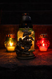 Fototapeta  - Different grave lanterns with burning candles on stone surface at night
