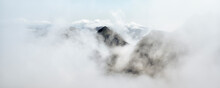 Scenic View Of Mountain Peak Seen Through Clouds