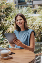 Smiling Businesswoman With Tablet Computer At Back Yard