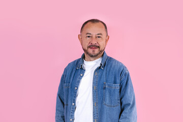 portrait of hispanic senior man wearing casual clothes smiling at camera on pink background in Mexico Latin America	
