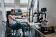© Westend61 - Photographer sitting on chair by desktop PC in studio