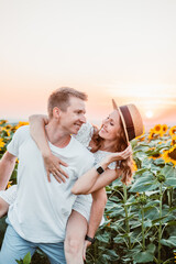 Poster - cute couple at sunflowers field on sunset