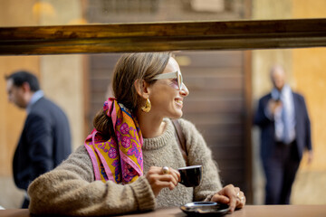 woman drinking espresso coffee at traditional old style italian cafe on a bar at window on cozy stre