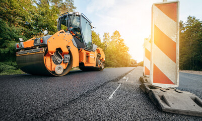 Vibratory asphalt rollers compactor compacting new asphalt pavement. Road service repairs the highway