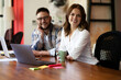 © JustLife - Colleagues drinking coffee in office. Businesswoman and businessman discussing work in office.