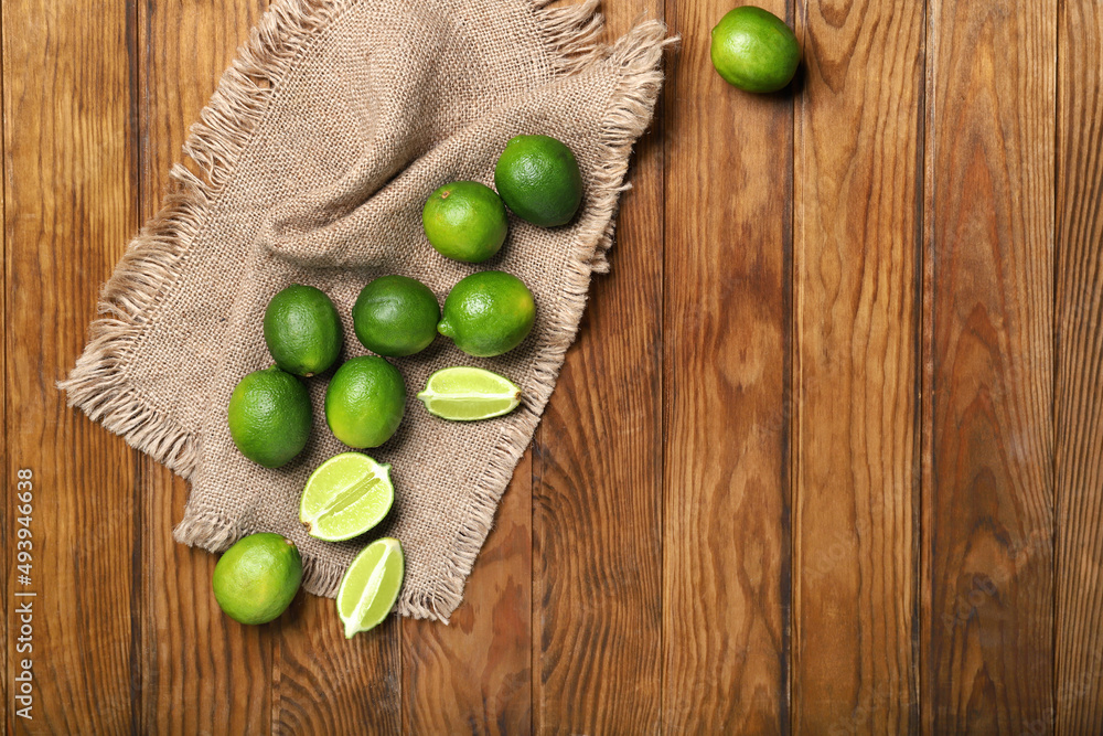 Fresh juicy limes on wooden background