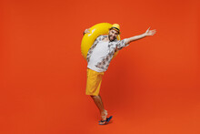 Full Body Young Cool Tourist Man Wear Beach Shirt Hat Hold Inflatable Ring Stand On Toes Dance Lean Back Isolated On Plain Orange Background Studio Portrait Summer Vacation Sea Rest Sun Tan Concept.