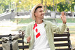 © Pixel-Shot - Male tourist with flag of Canada sitting on bench in park