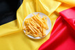 Plate with tasty french fries on Belgian flag, top view
