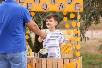 Wall Mural - Cute boy selling lemonade in park