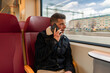 © TxemaPhoto - Man talking on the phone. traveling by train