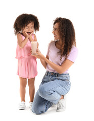 Poster - Surprised little African-American girl and her mother with glass of sweet cocoa on white background