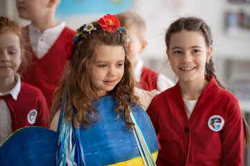 Wall Mural - Schoolchildren welcoming new Ukrainian classmate, concept of enrolling Ukrainian kids to schools.