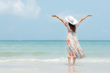 Summer vacations. Lifestyle woman relax and chill on beach background.  Asia happy young people with white dress raise arm on the wave sea, summer trips walking enjoy  tropical beach