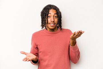 Young African American man isolated on white background makes scale with arms, feels happy and confident.