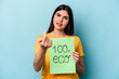 © Asier - Young caucasian woman holding 100% eco placard isolated on blue background pointing with finger at you as if inviting come closer.