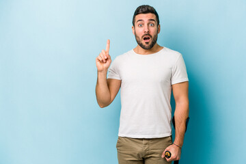 Wall Mural - Young man with crutches isolated on blue background having some great idea, concept of creativity.