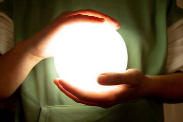 Wall Mural - moon lamp turn on with white background hold by two hands of a girl