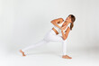 © Jose MarÍa Peral Villavert/Wirestock Creators - Spanish young woman doing a yoga pose on a white background.