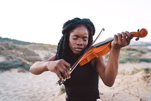 Dreamy Black Woman Playing Violin At Seaside